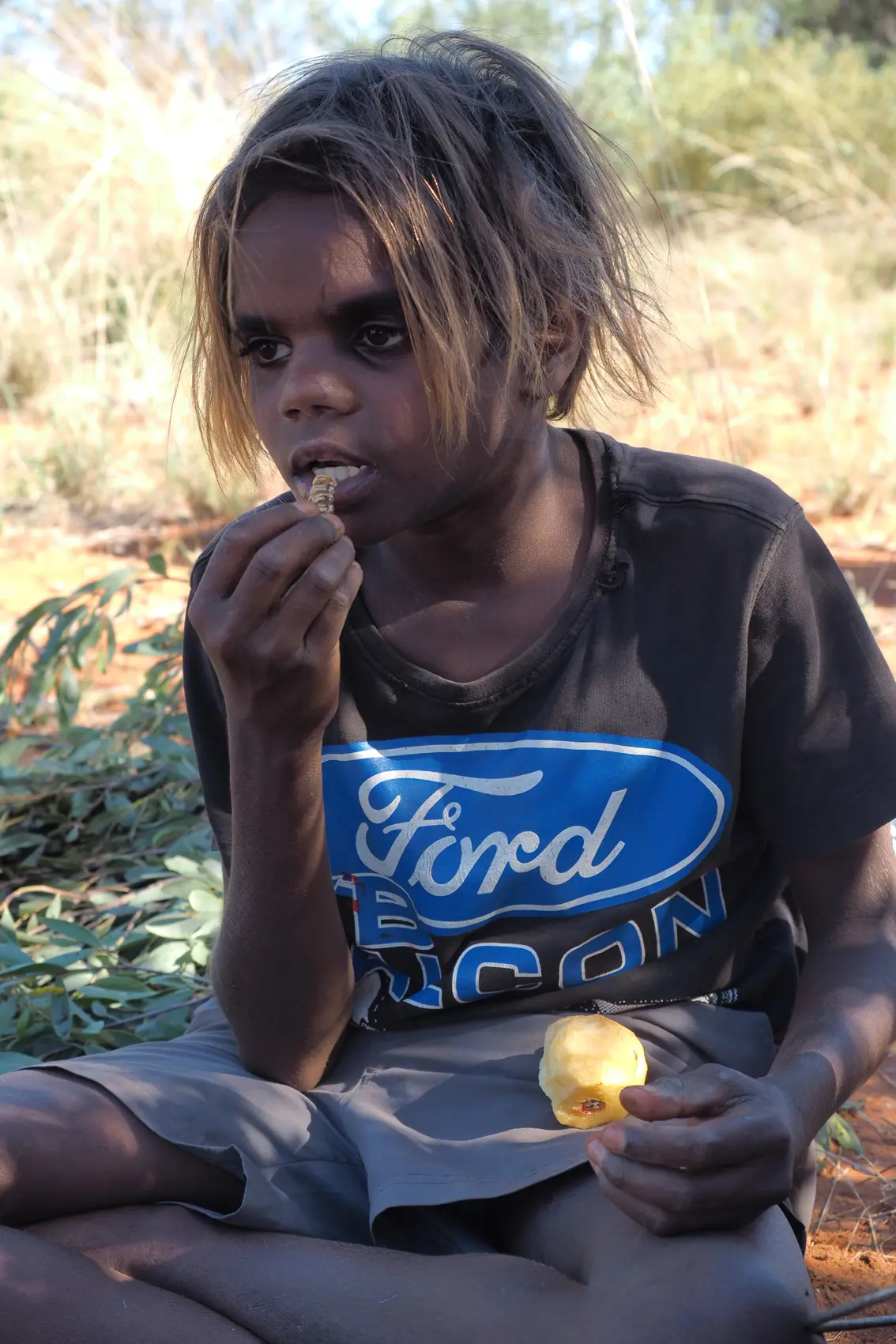 Yuendumu Gold 08 — Aboriginal boy eating witchetty grub: Yuendumu, 2017 Aboriginal boy eating Witchetty grub near Yuendumu. Date: 10 December 2017