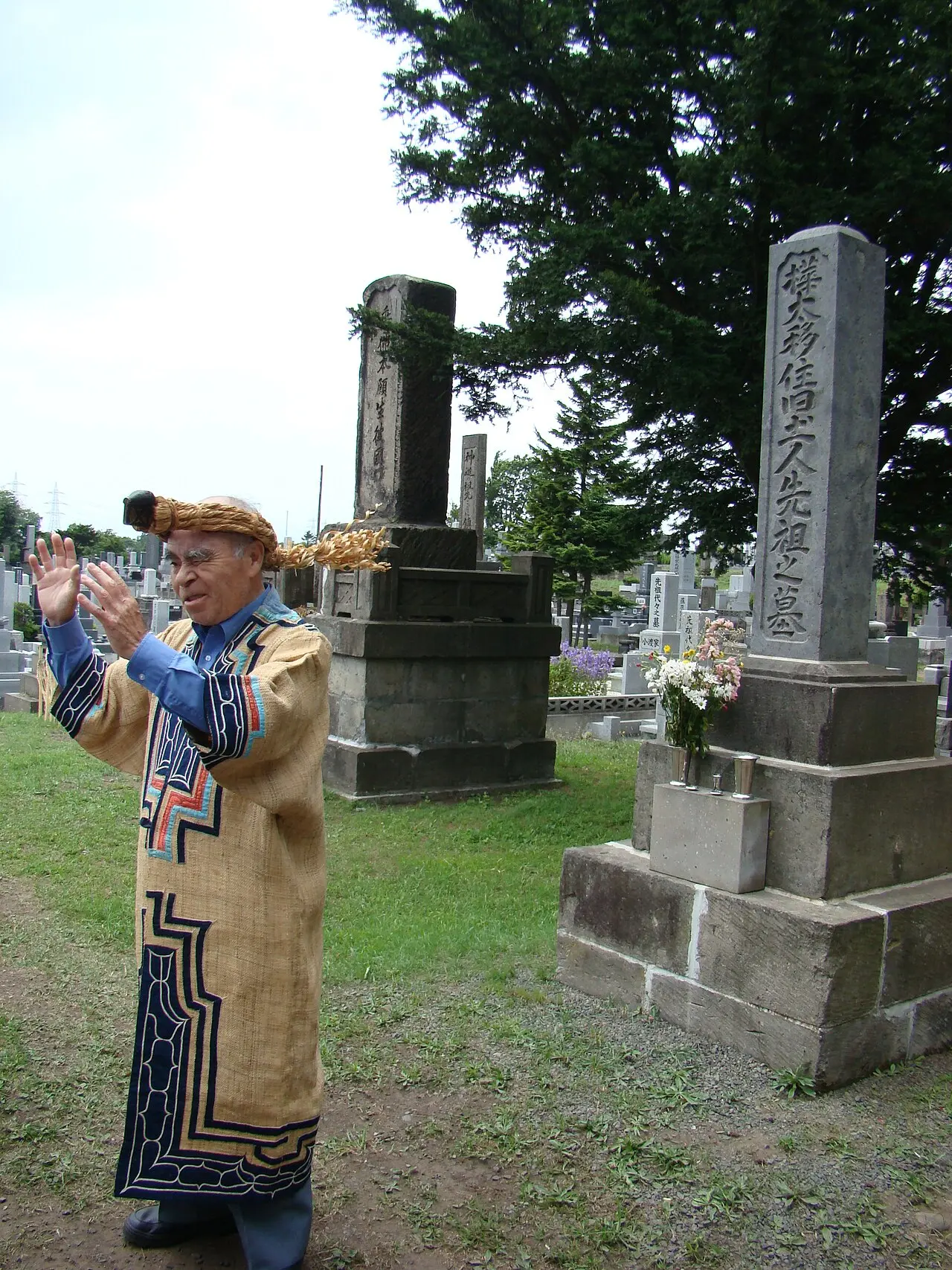 Ogawa Ryukichi devant un monument dédié aux victimes aïnoues de Sakhaline — Takayoshi Ogawa [ja], militant des droits des Aïnous, prend la parole devant un mémorial dédié aux Aïno…