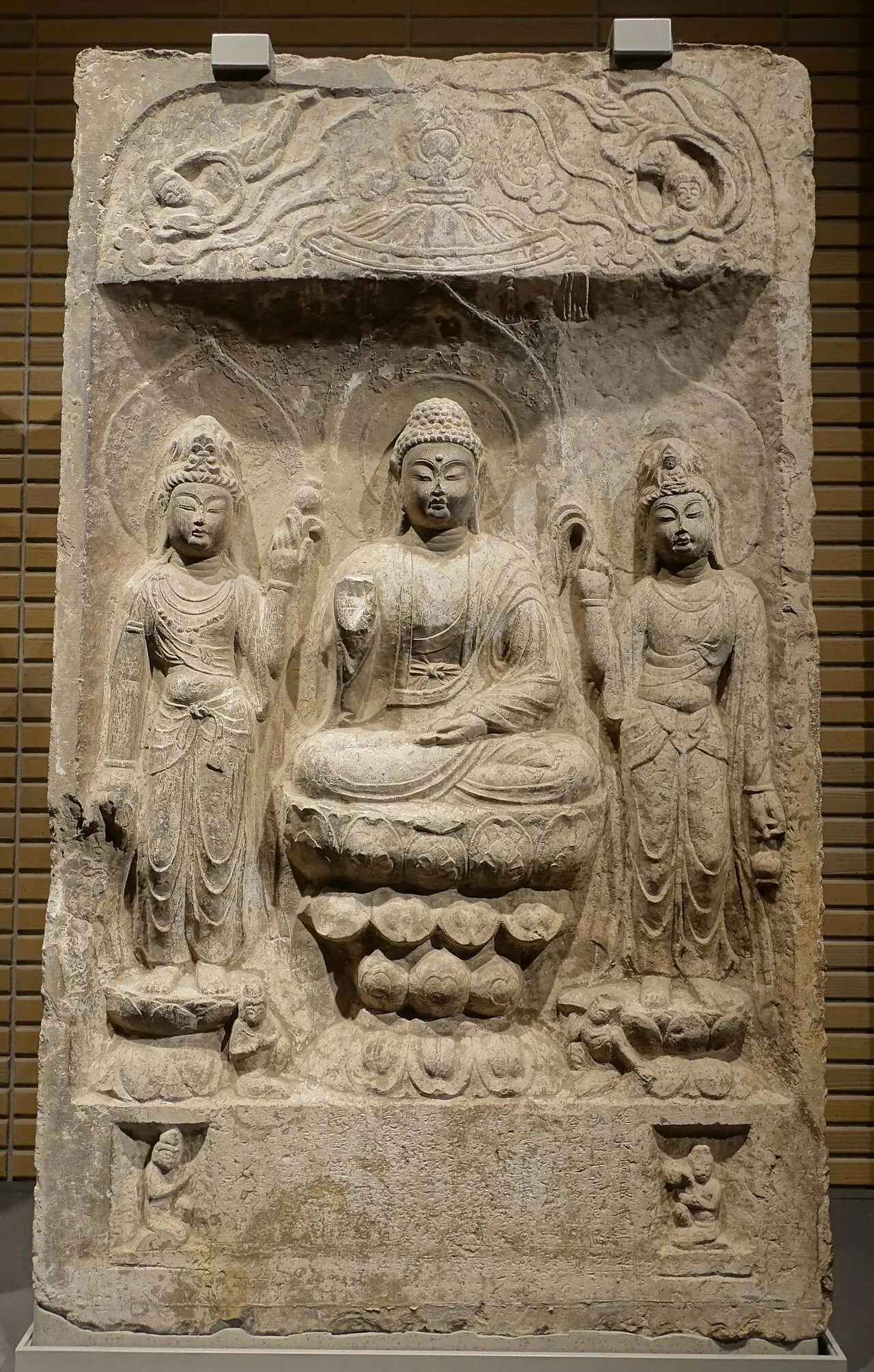 Amitabha triad in a niche, Baoqingsi temple, Xi'an, Shaanxi province, China, Tang dynasty, dated 703 CE Exhibit in the Tokyo National Museum - Tokyo, Japan. Amitabha triad in a niche, Baoqingsi temple, Xi'an, Shaanxi province, China, Tang dynasty, dated 703 AD, limestone DSC08704 — Amitabha triad in a niche, Baoqingsi temple, Xi'an, S…